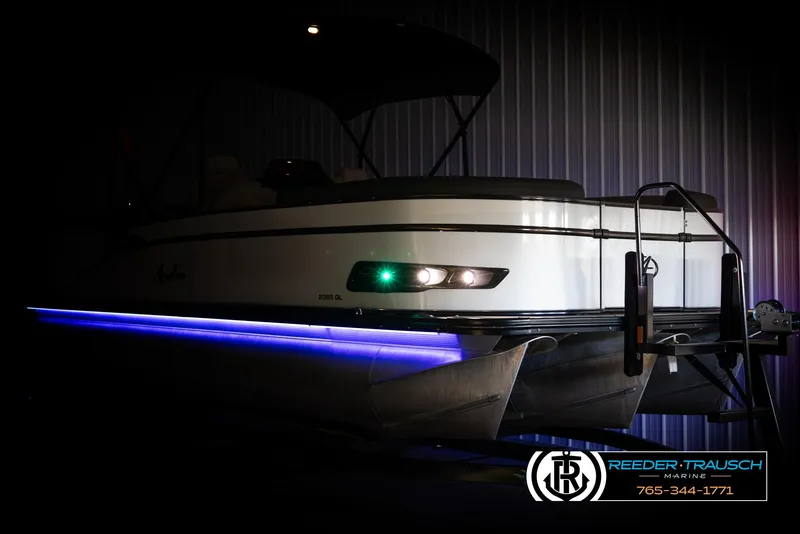 Slide: The Image of 2021 Avalon Catalina QL pontoon boat with blue LED lights in a dimly lit setting. - 4