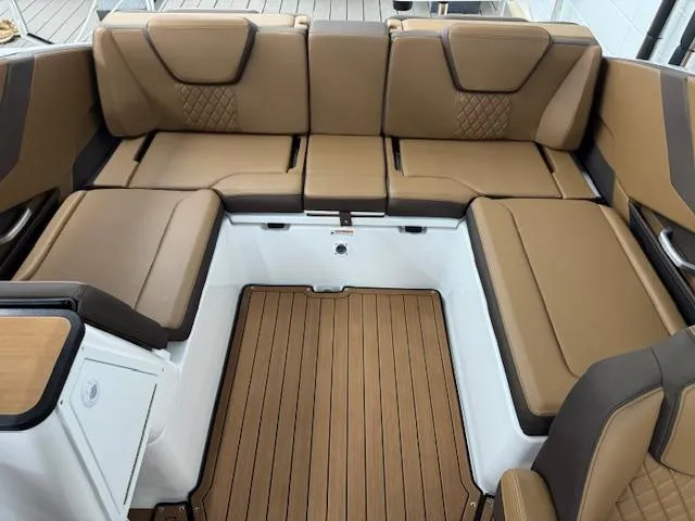 Slide: The Image of 2025 Yamaha Boats 252SD interior with brown cushioned seating and wood-style flooring. - 12