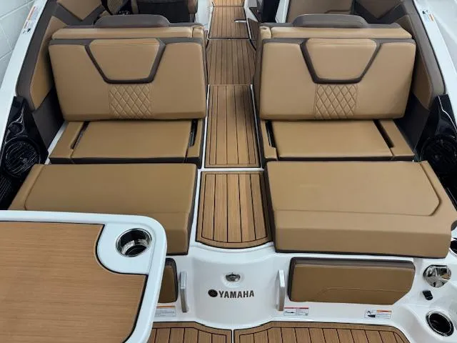 Slide: The Image of 2025 Yamaha Boats 252SD interior with tan seating and wood-style flooring. - 18