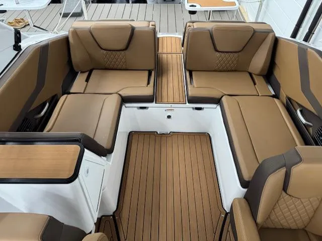 Slide: The Image of 2025 Yamaha Boats 252SD interior with luxurious brown seating and wood-style flooring. - 9