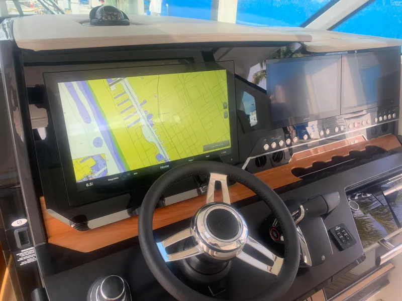 Slide: The Image of 2022 Tiara Yachts 48 LS helm with navigation screens and steering wheel. - 12