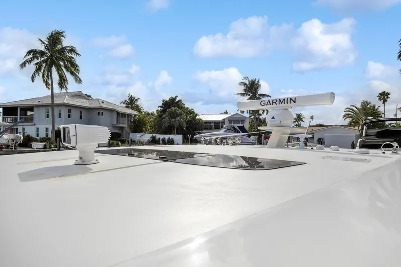 Slide: The Image of 2022 Tiara Yachts 48 LS with Garmin radar, docked near palm trees and houses. - 9
