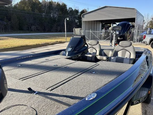 Slide: The Image of 2019 Skeeter ZX250 bass boat with dual seats, parked near a garage. - 12