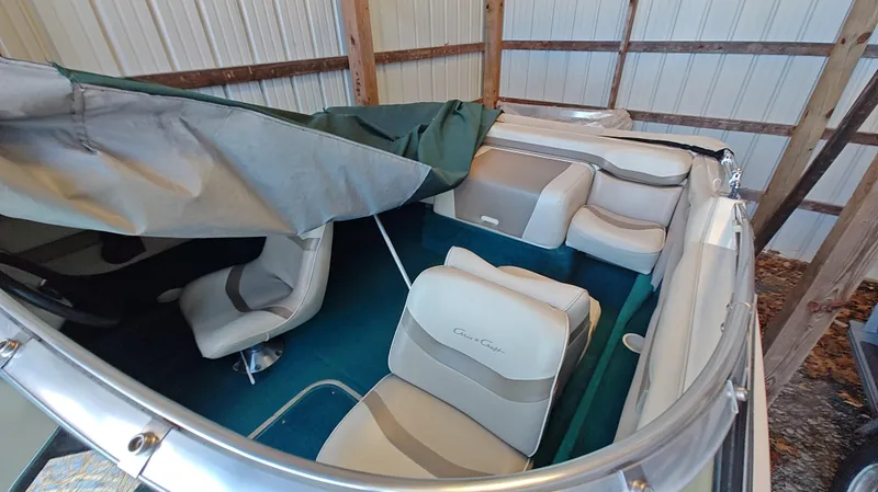 Slide: The Image of 1994 Chris-Craft 197 boat interior with white seats and green cover in storage. - 3
