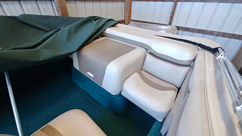 Slide: The Image of Interior of a 1994 Chris-Craft 197 boat with beige seating and green cover. - 8