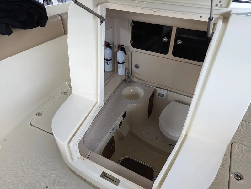 Slide: The Image of 2015 Chris-Craft Catalina 29 boat interior with compact bathroom and fire extinguishers. - 17