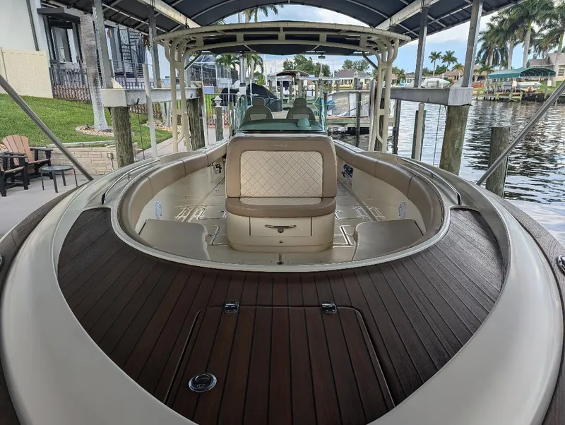Slide: The Image of 2015 Chris-Craft Catalina 29 boat with elegant wood deck and seating, docked under a canopy. - 8