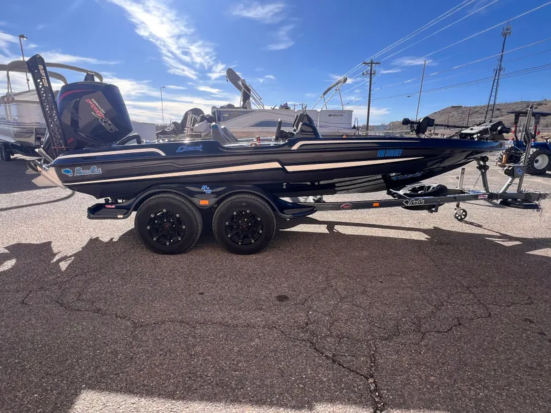 Slide: The Image of 2021 Bass Cat Caracal boat on trailer, parked outdoors under a clear sky. - 1