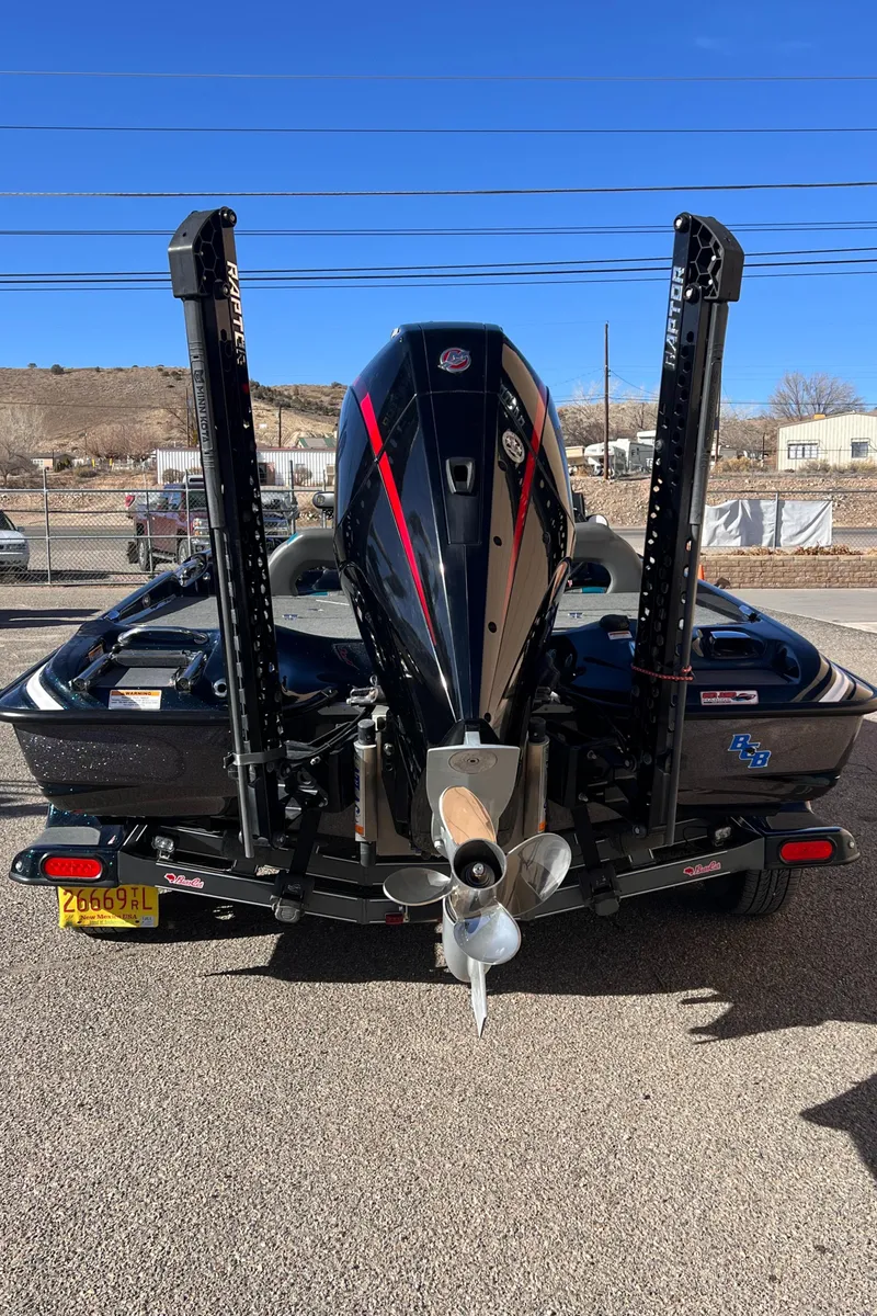 Slide: The Image of 2021 Bass Cat Caracal boat, rear view with motor and power poles. - 2
