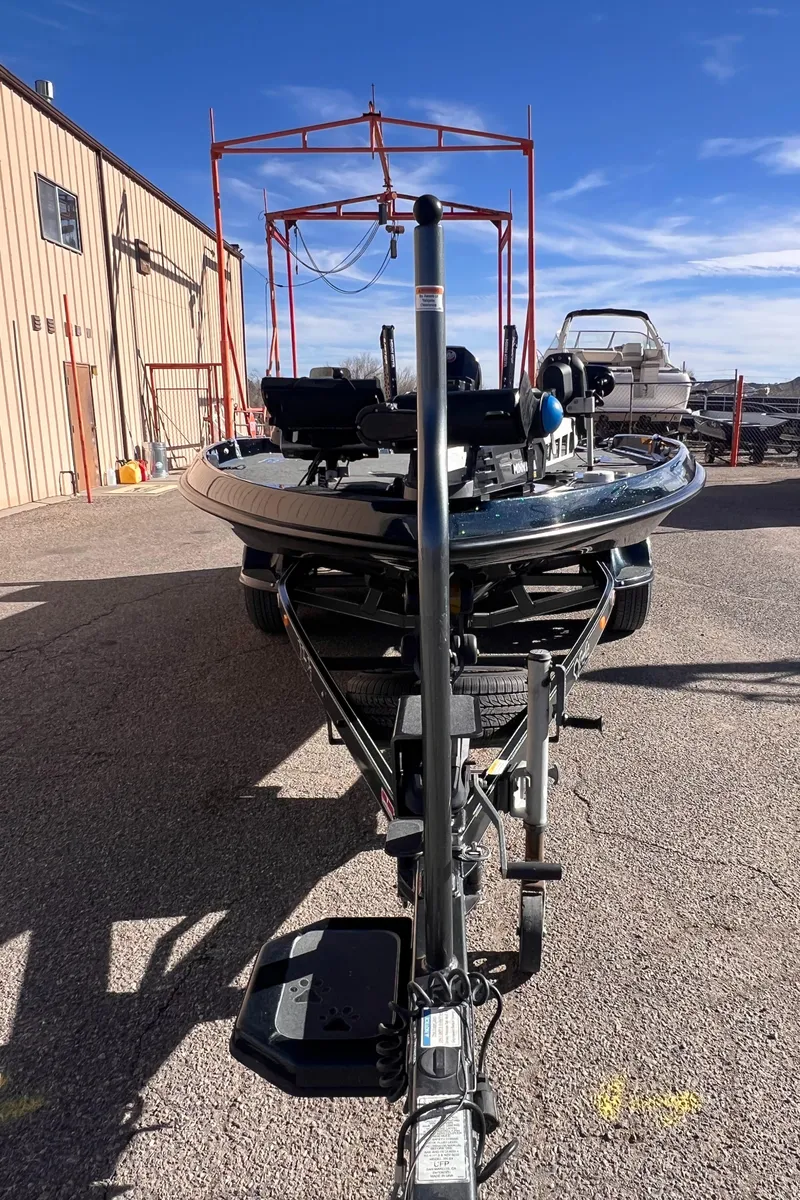 Slide: The Image of 2021 Bass Cat Caracal boat on trailer, parked outdoors under clear blue sky. - 3