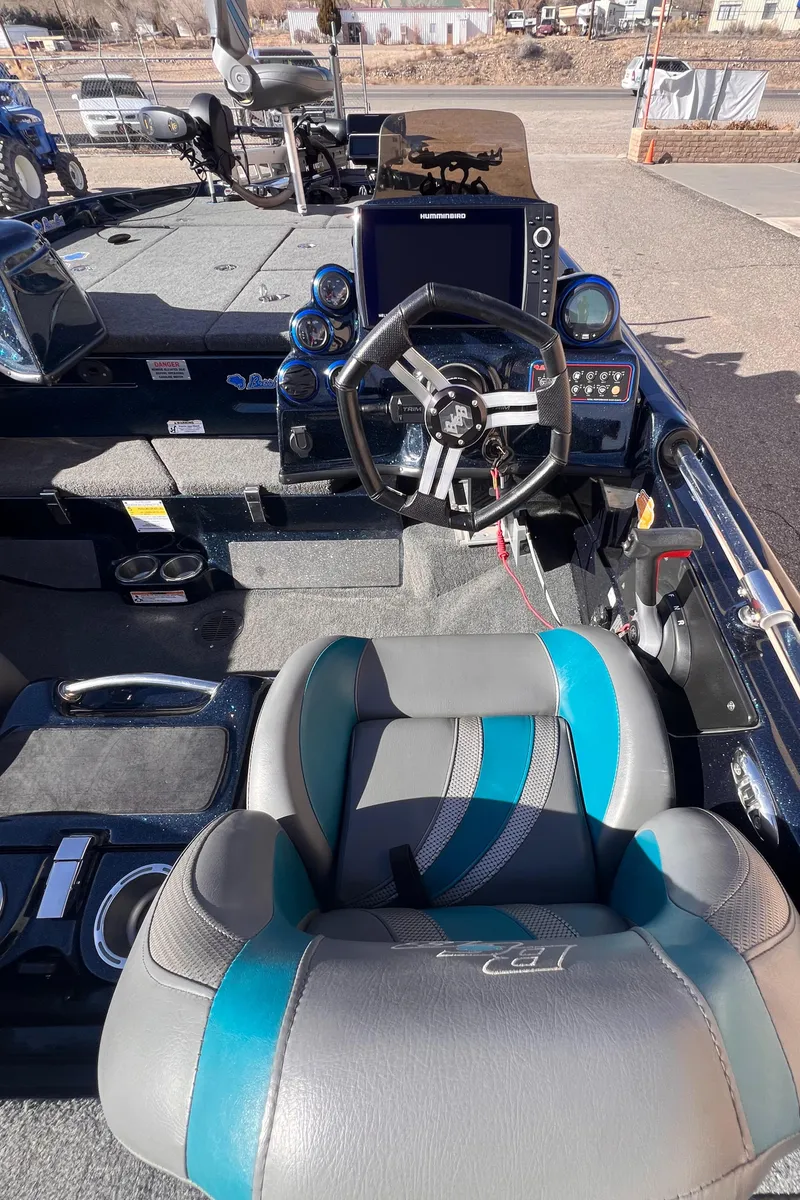 Slide: The Image of 2021 Bass Cat Caracal boat interior with steering wheel and seating. - 4