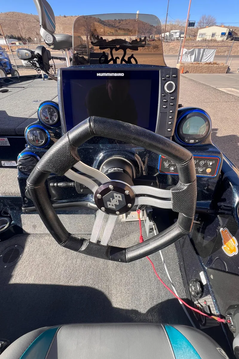 Slide: The Image of 2021 Bass Cat Caracal boat dashboard with steering wheel and navigation system. - 6