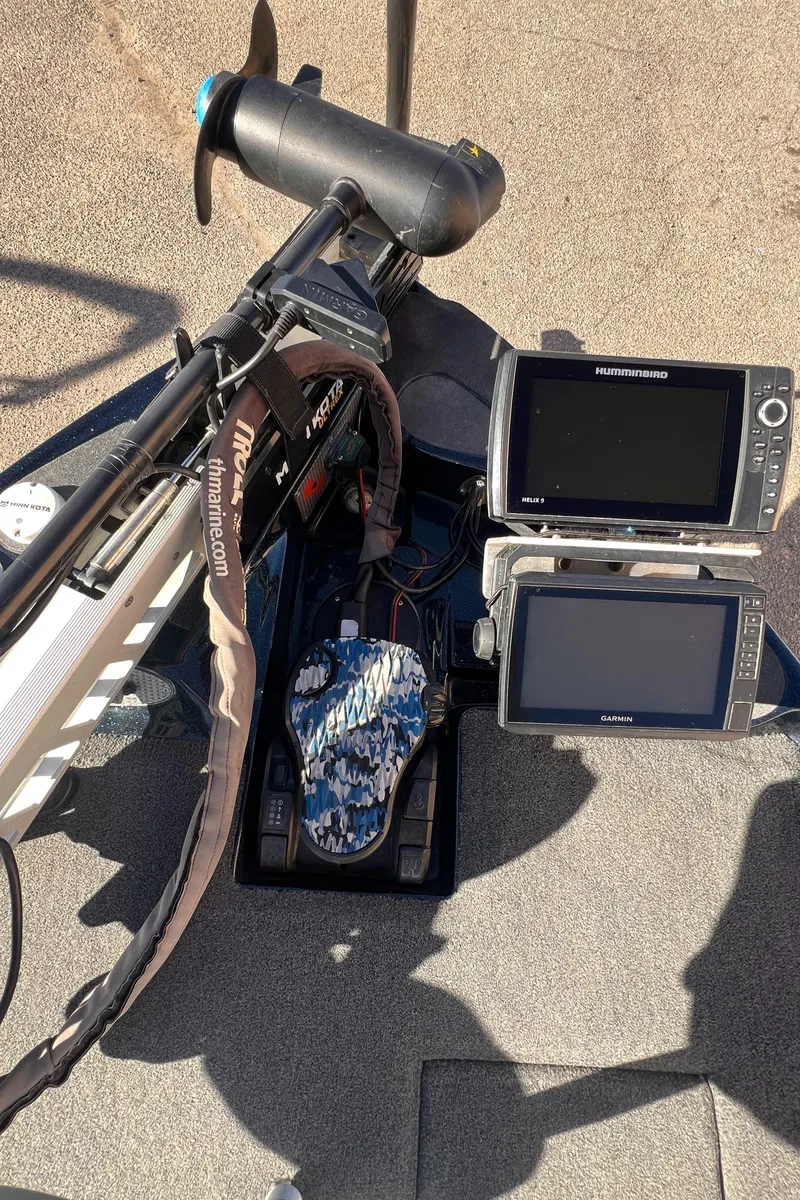 Slide: The Image of 2021 Bass Cat Caracal boat dashboard with dual fish finders and trolling motor. - 9