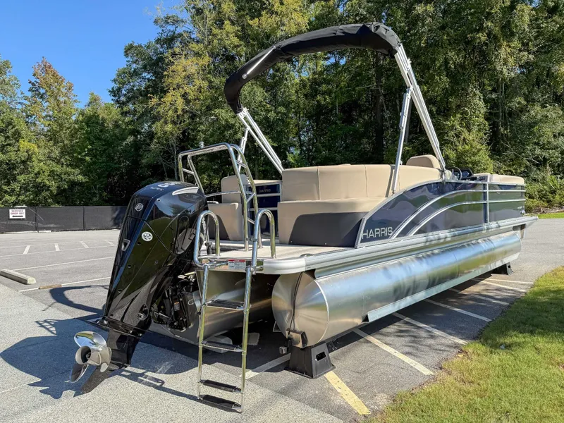Slide: The Image of 2025 Harris Cruiser 250 CWDH pontoon boat parked outdoors. - 7