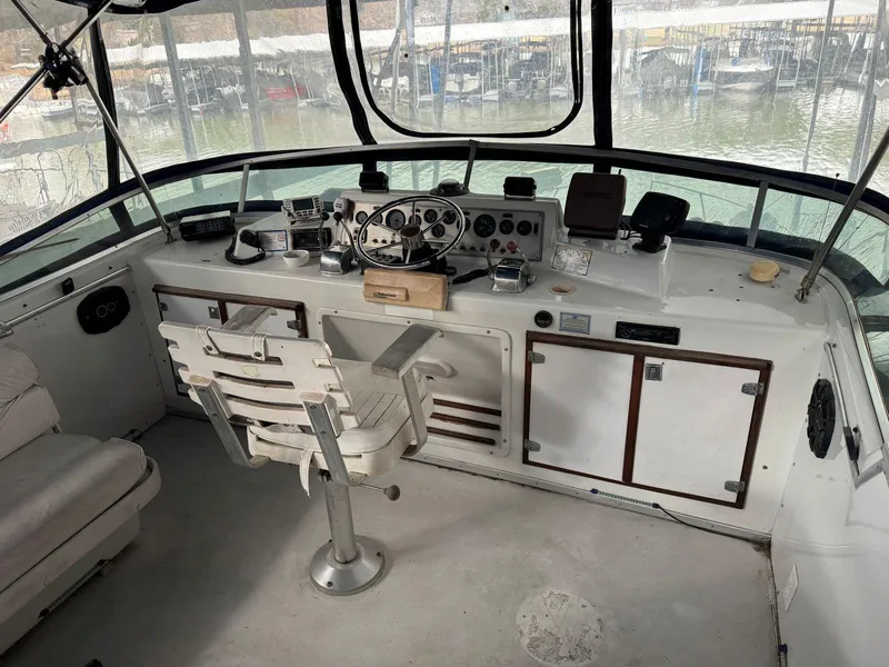 Slide: The Image of 1988 Chris-Craft 426 Catalina boat helm with steering wheel, controls, and seating. - 13
