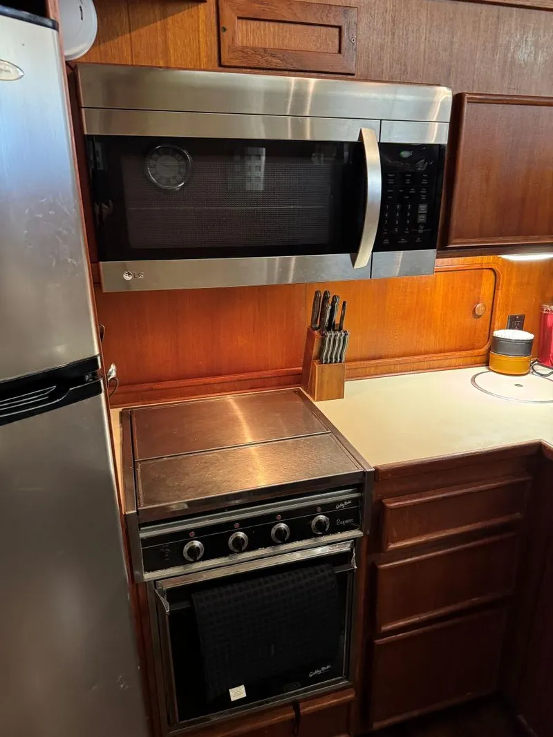 Slide: The Image of Kitchen area in 1988 Chris-Craft 426 Catalina with microwave, stove, and wooden cabinetry. - 28