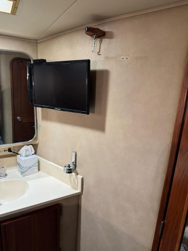 Slide: The Image of 1988 Chris-Craft 426 Catalina bathroom with TV, mirror, and sink. - 32