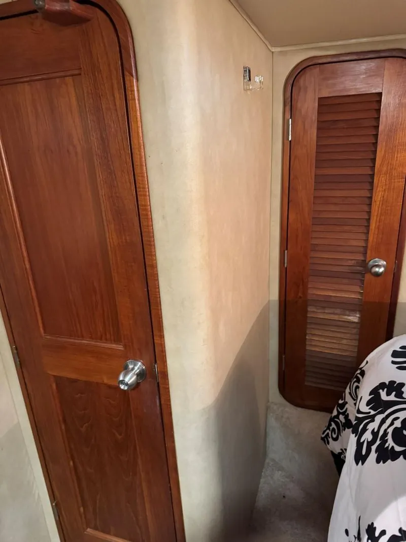 Slide: The Image of 1988 Chris-Craft 426 Catalina interior with wooden doors and patterned bedding. - 33