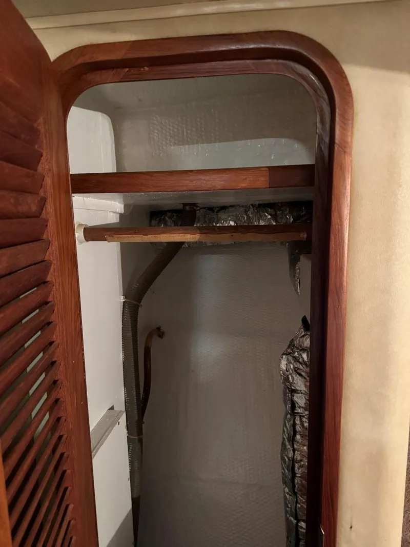 Slide: The Image of 1988 Chris-Craft 426 Catalina interior closet with wooden shelves and door. - 34