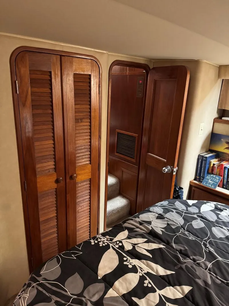 Slide: The Image of 1988 Chris-Craft 426 Catalina cabin interior with wooden doors and cozy bedding. - 45