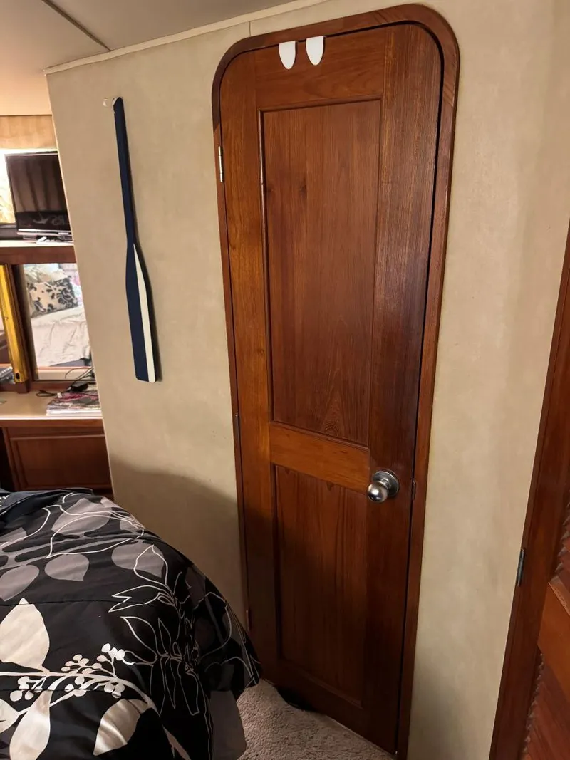 Slide: The Image of Wooden cabin door inside 1988 Chris-Craft 426 Catalina yacht, with decorative paddle on wall. - 49
