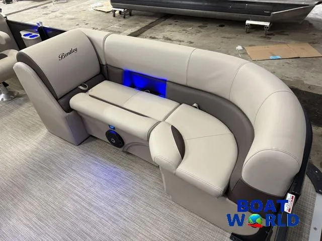 Slide: The Image of 2025 Bentley Pontoons Legacy 223 Navigator Quad Lounge interior with beige seating and blue lighting. - 9
