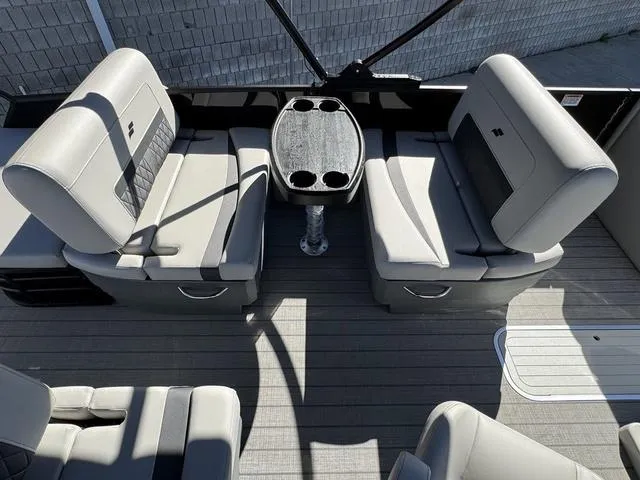 Slide: The Image of 2025 Starcraft CX 23 RL boat interior view at a showroom with other boats displayed. - 15