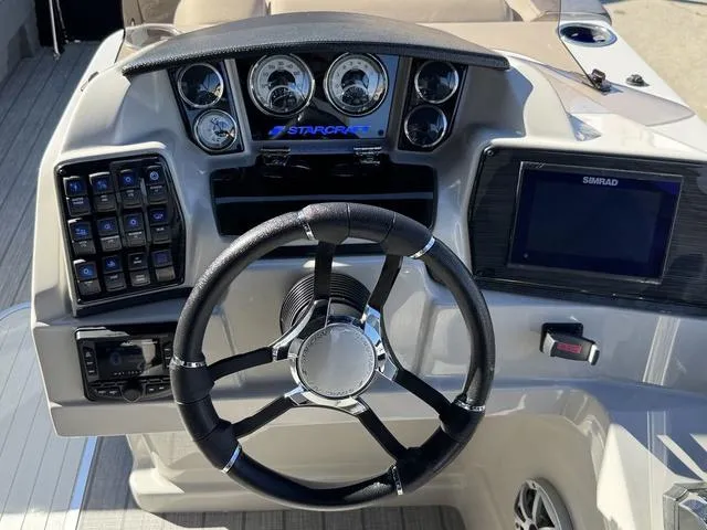 Slide: The Image of 2025 Starcraft CX 23 RL boat dashboard with steering wheel and control panel. - 22