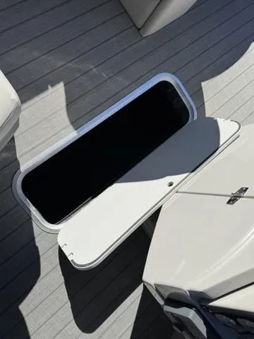 Slide: The Image of 2025 Starcraft CX 23 RL boat storage compartment with open hatch on deck. - 28