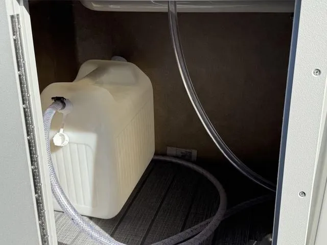 Slide: The Image of Water container and tubing inside a 2025 Starcraft CX 23 RL compartment. - 39