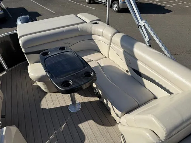 Slide: The Image of 2017 Bennington 20SLMX boat interior with beige seating and a central table. - 9