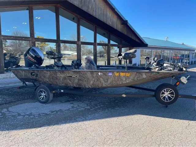 Slide: The Image of 2022 G3 Sportsman 1710 boat with camouflage design, parked outside a building. - 1