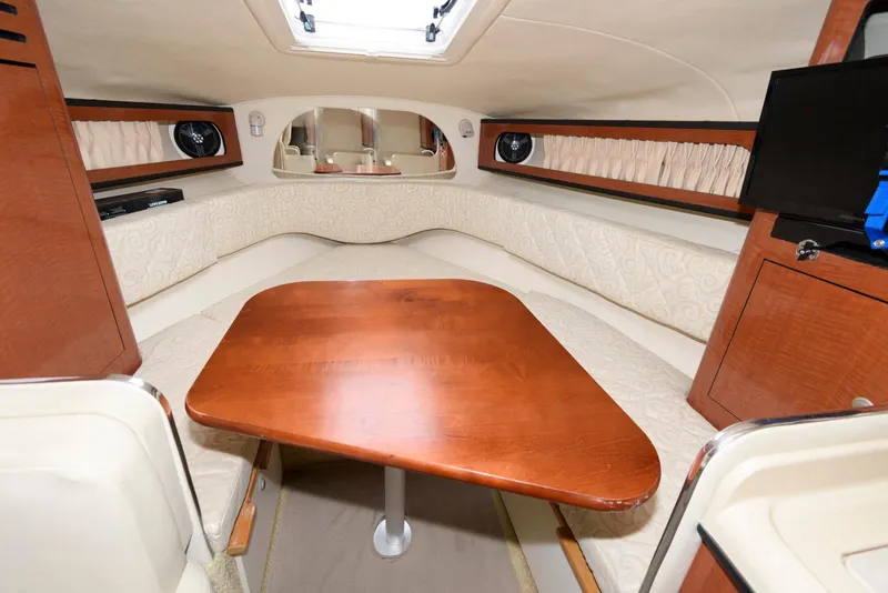 Slide: The Image of 2005 Sea Ray 280 Sundancer cabin interior with wooden table and seating area. - 13