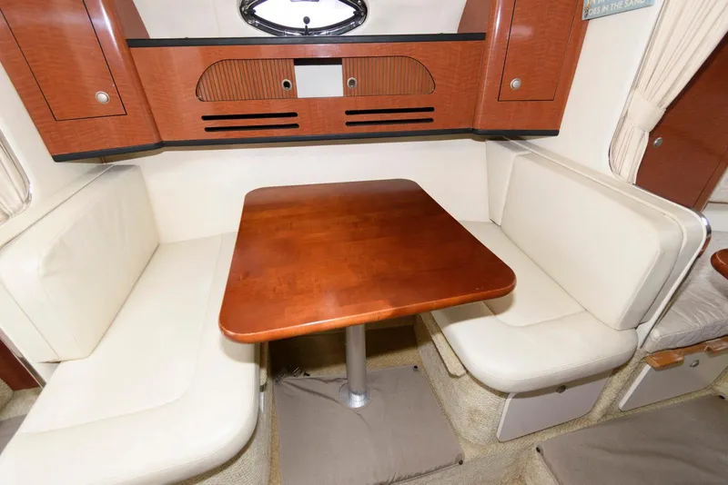 Slide: The Image of Interior of 2005 Sea Ray 280 Sundancer with wooden table and white seating. - 14