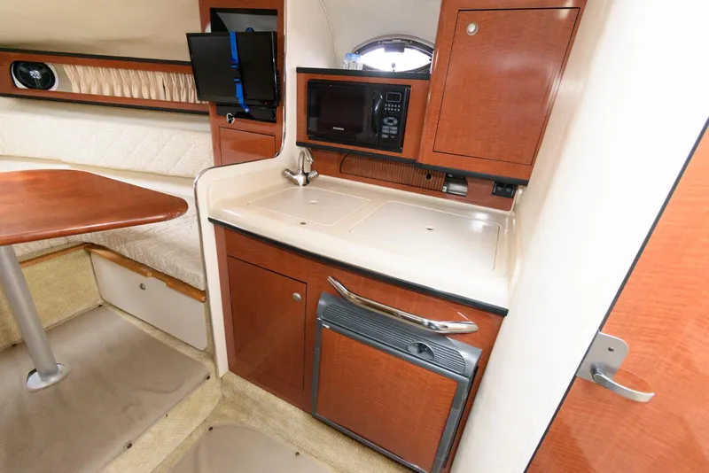 Slide: The Image of 2005 Sea Ray 280 Sundancer cabin interior with kitchenette and seating area. - 15