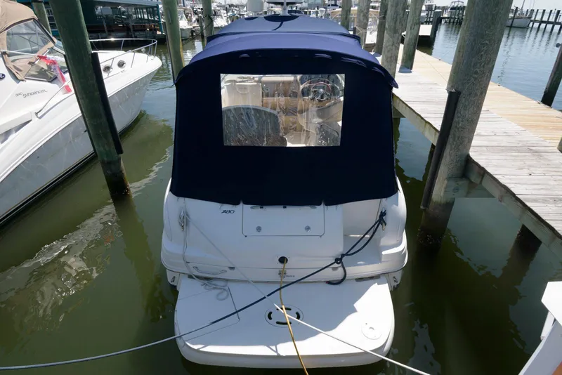 Slide: The Image of 2005 Sea Ray 280 Sundancer docked, rear view with blue canopy, in marina setting. - 4