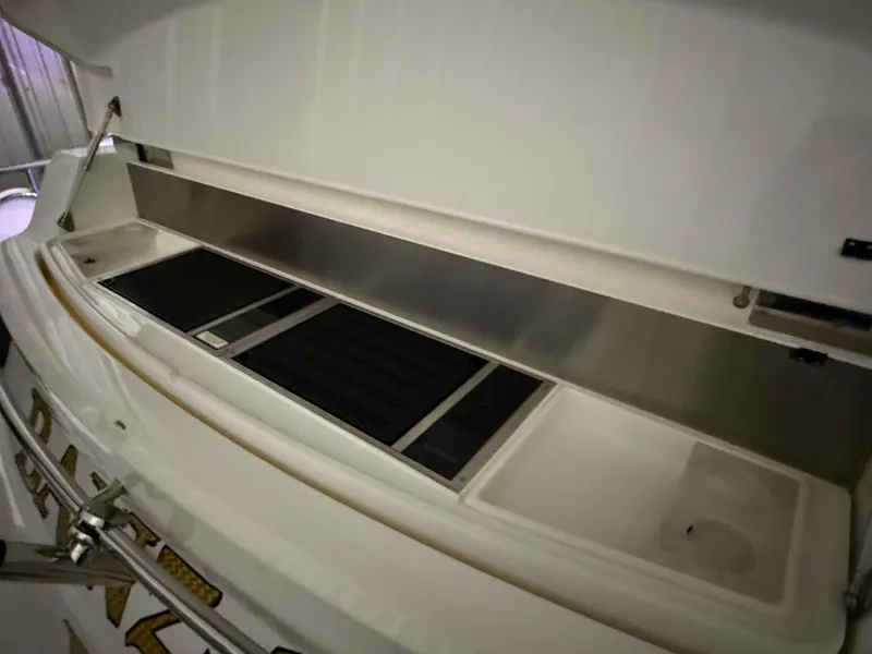 Slide: The Image of 2019 Riviera 4800 Sport Yacht storage compartment with open lid, showcasing interior space. - 14