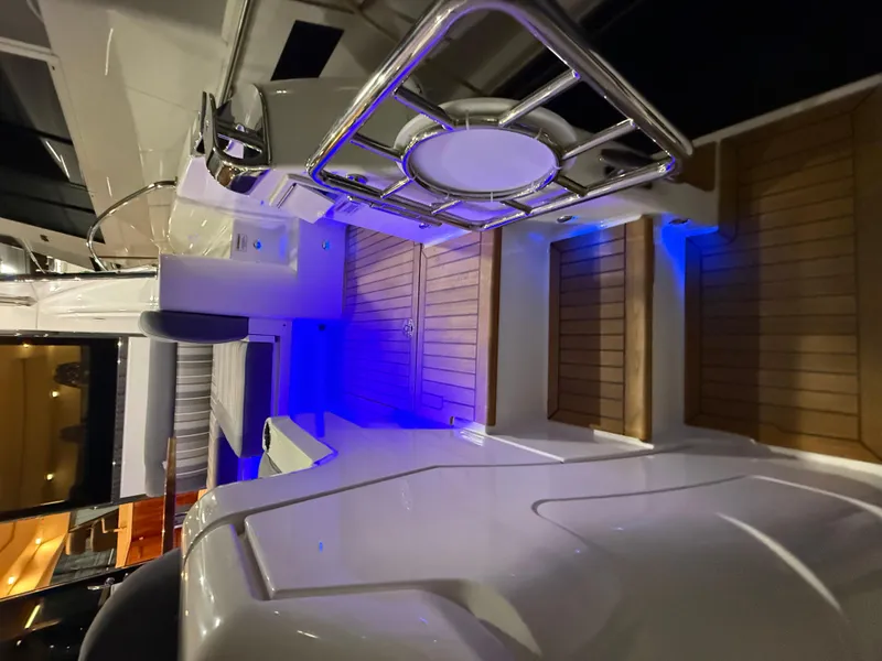 Slide: The Image of Riviera 4800 Sport Yacht 2019 interior with blue LED lighting and wooden flooring. - 15