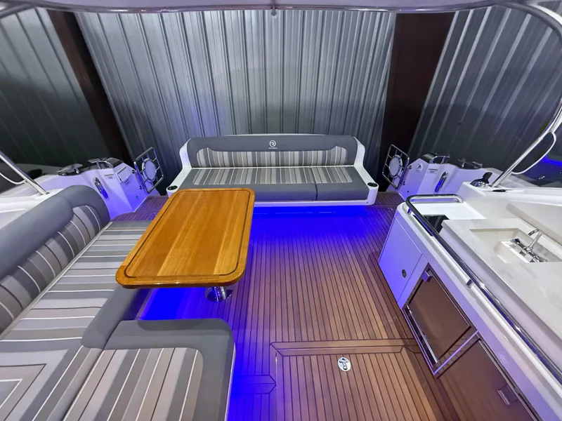 Slide: The Image of 2019 Riviera 4800 Sport Yacht interior with elegant seating, wooden table, and ambient lighting. - 20