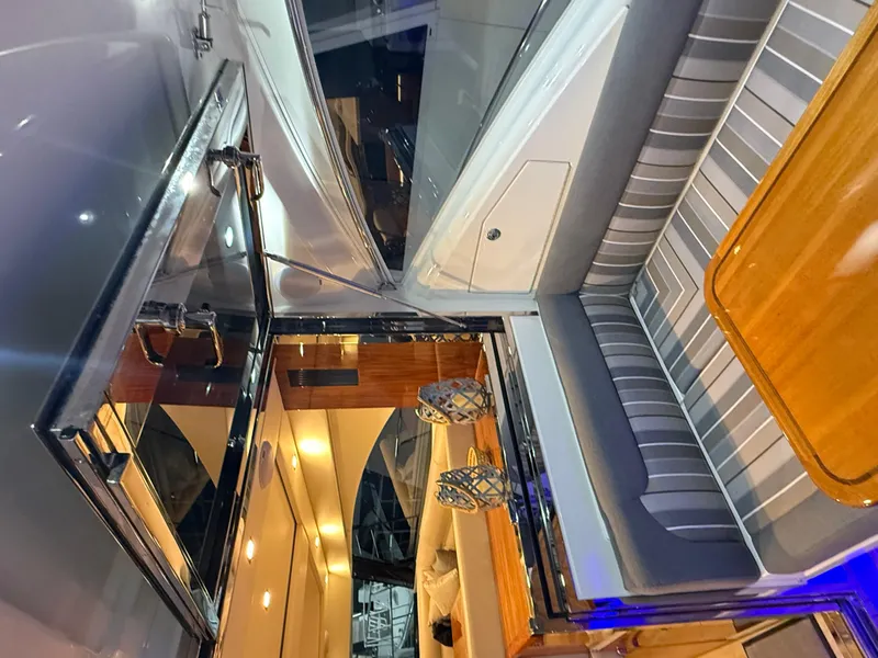 Slide: The Image of Interior of 2019 Riviera 4800 Sport Yacht with elegant seating and wooden table. - 22
