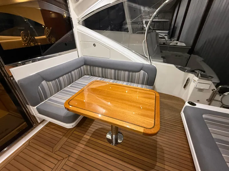 Slide: The Image of 2019 Riviera 4800 Sport Yacht interior with elegant seating and wooden table. - 24