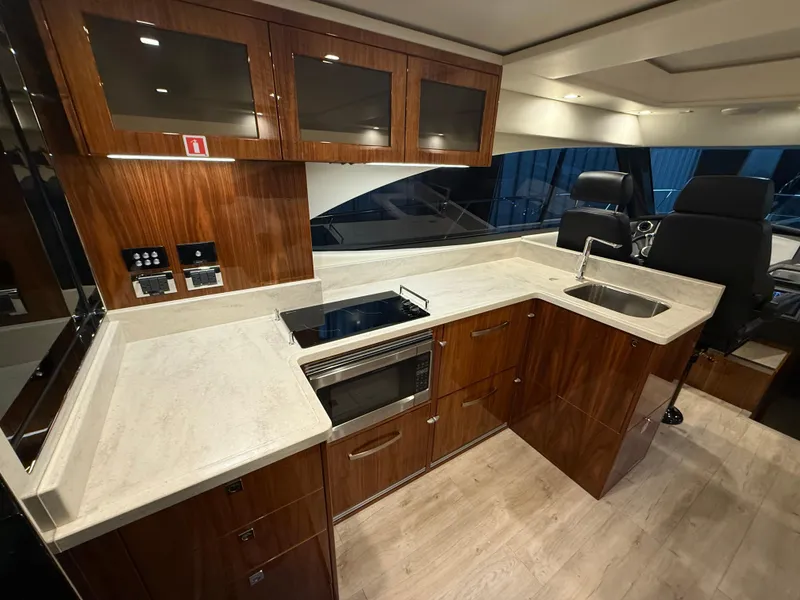 Slide: The Image of Luxurious kitchen interior of 2019 Riviera 4800 Sport Yacht with modern appliances and wood finish. - 31
