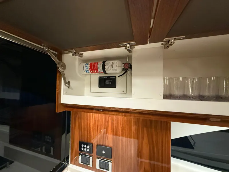 Slide: The Image of Interior of 2019 Riviera 4800 Sport Yacht with fire extinguisher and control panel. - 36