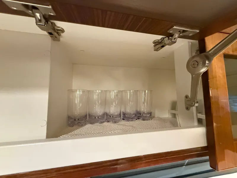 Slide: The Image of Open cabinet with glasses inside a 2019 Riviera 4800 Sport Yacht. - 37