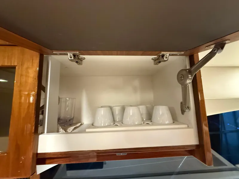 Slide: The Image of Open cabinet with cups and glassware in 2019 Riviera 4800 Sport Yacht. - 38