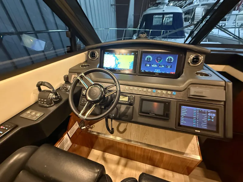 Slide: The Image of 2019 Riviera 4800 Sport Yacht helm with advanced navigation displays and controls. - 48