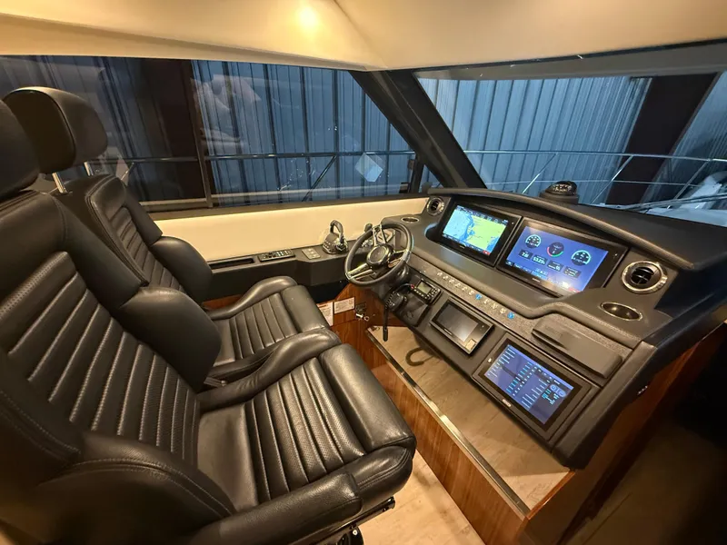 Slide: The Image of 2019 Riviera 4800 Sport Yacht helm with leather seats and advanced navigation displays. - 49
