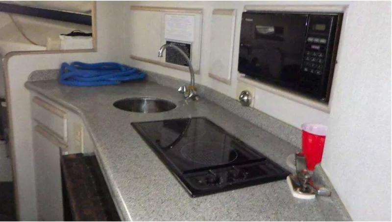 Slide: The Image of 1995 Blackfin 33 Convertible yacht kitchen with sink, stove, and microwave. - 10