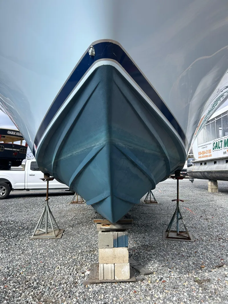 Slide: The Image of 1995 Blackfin 33 Convertible boat on stands, viewed from the front, in a gravel lot. - 13
