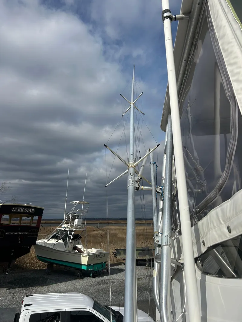Slide: The Image of 1995 Blackfin 33 Convertible boat with antennas, docked under cloudy skies. - 17